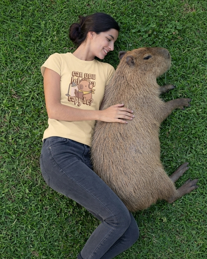 Woman lying on grass with a large capybara